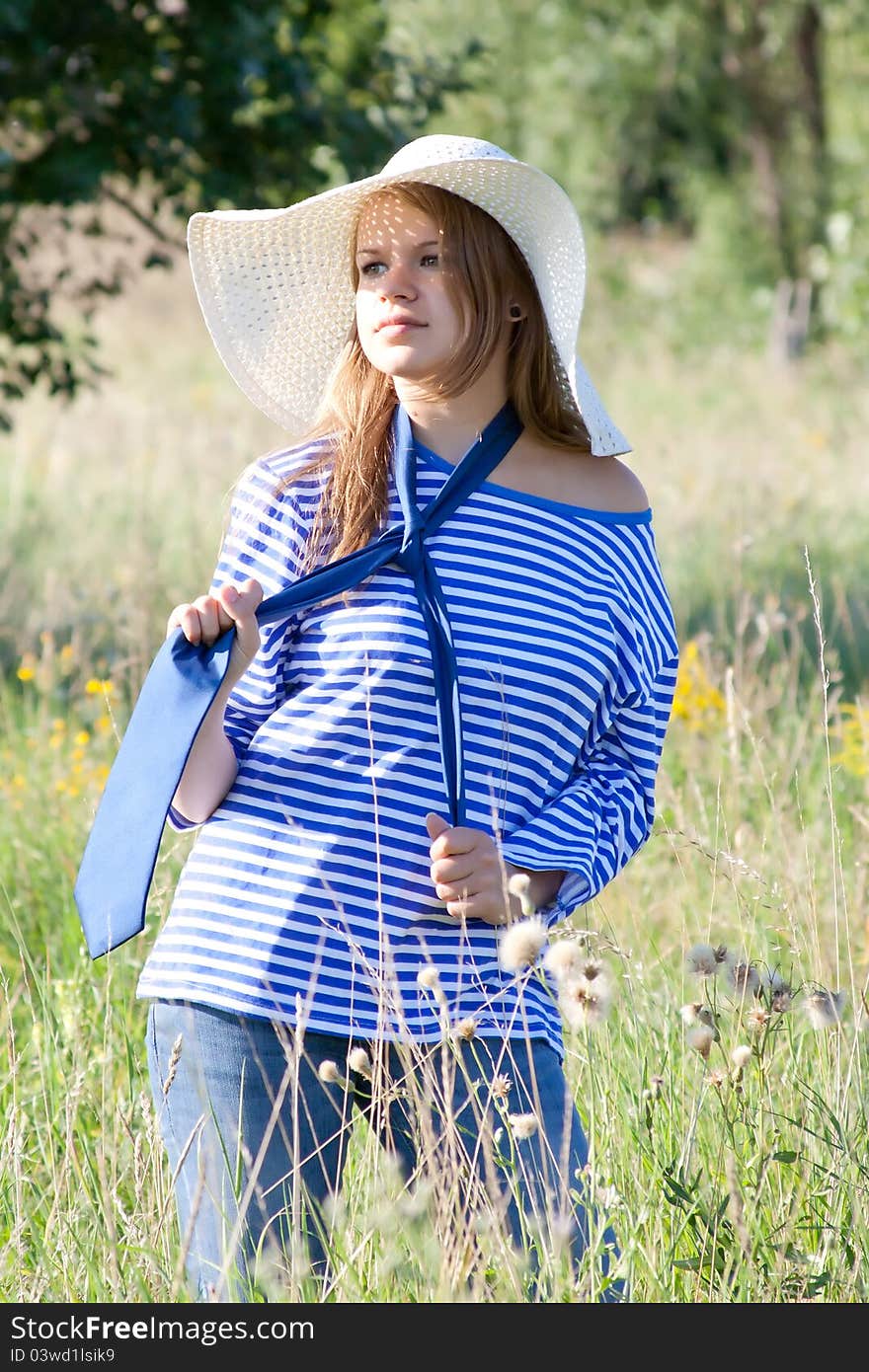 Beautiful girl in the shirt on the grass outdoors shooting