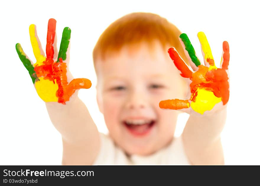 Adorable red-haired boy with focus on hands painted in bright colors. Adorable red-haired boy with focus on hands painted in bright colors