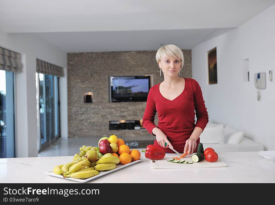 Happy young beautiful blonde woman prepare food in the kitchen at home. Happy young beautiful blonde woman prepare food in the kitchen at home