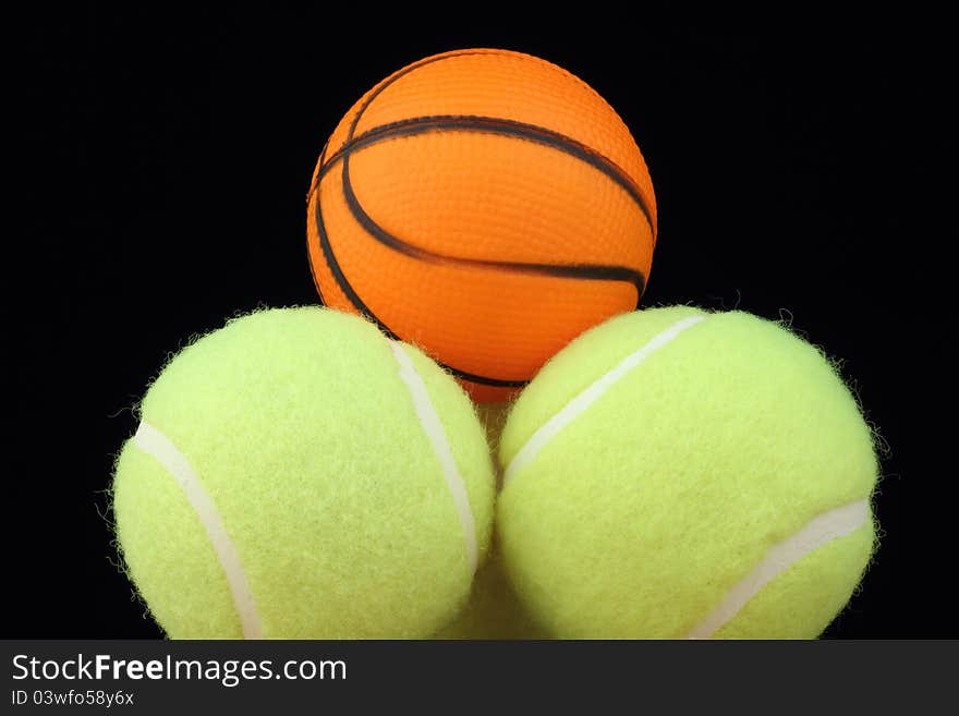 Basketball on tenis balls on black background