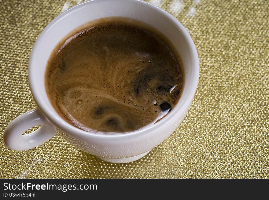 Cup of coffee with froth on a plate. Cup of coffee with froth on a plate