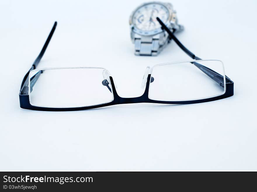 Close-up of glasses and wrist watch isolated on a white background. Close-up of glasses and wrist watch isolated on a white background.