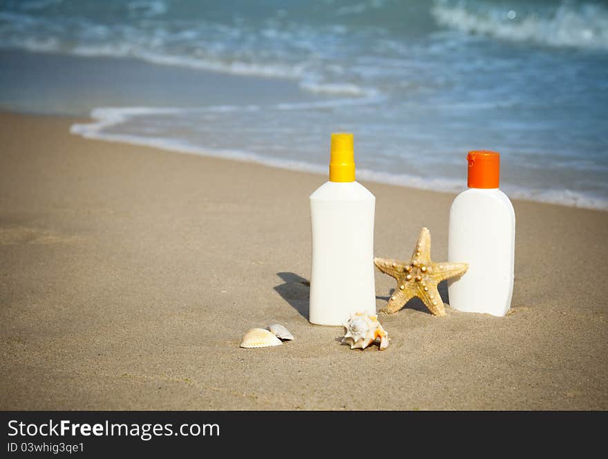 Suntan Lotion Flacons on the Beach with copy space / seasonal