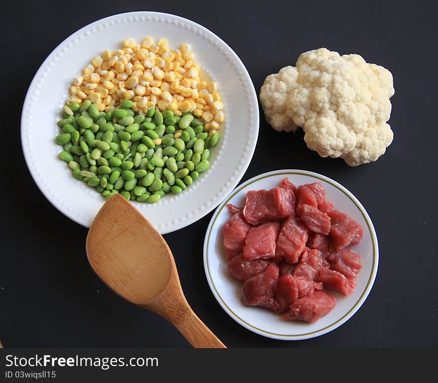 Beef,soy bean kernels,corn,and couliflower prepared for eating