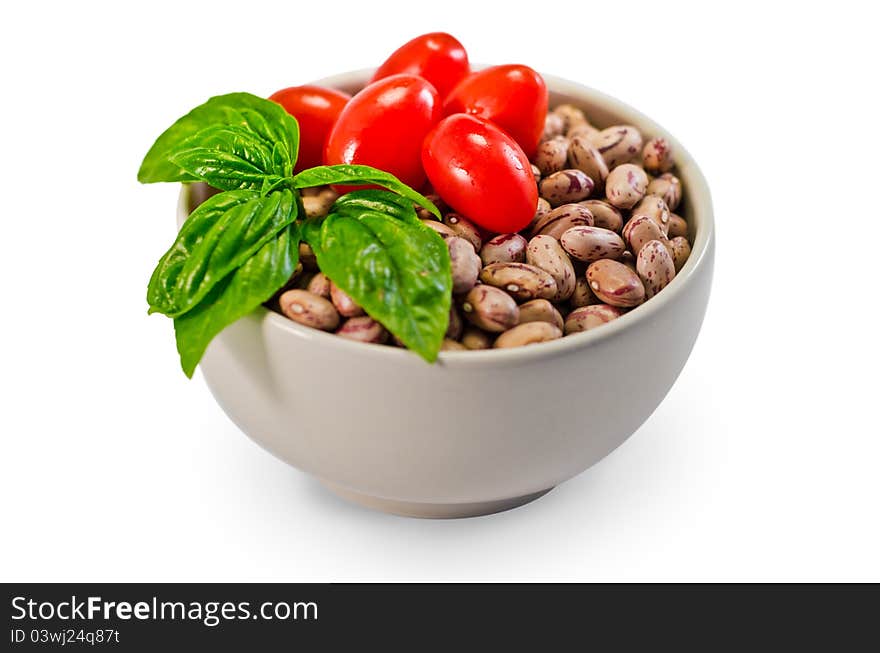 Beans, tomatoes and basil in a white cup