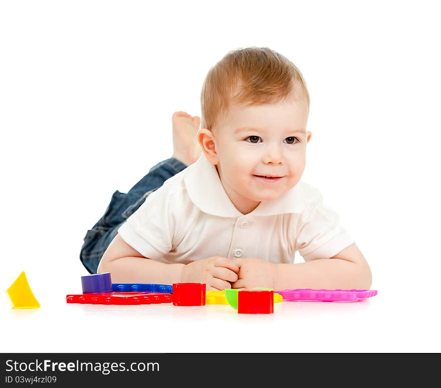 Child is playing with toys while lying on floor, isolated over white. Child is playing with toys while lying on floor, isolated over white