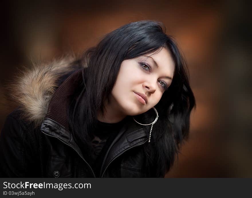 Young woman in a leather jacket on blurred background. Young woman in a leather jacket on blurred background