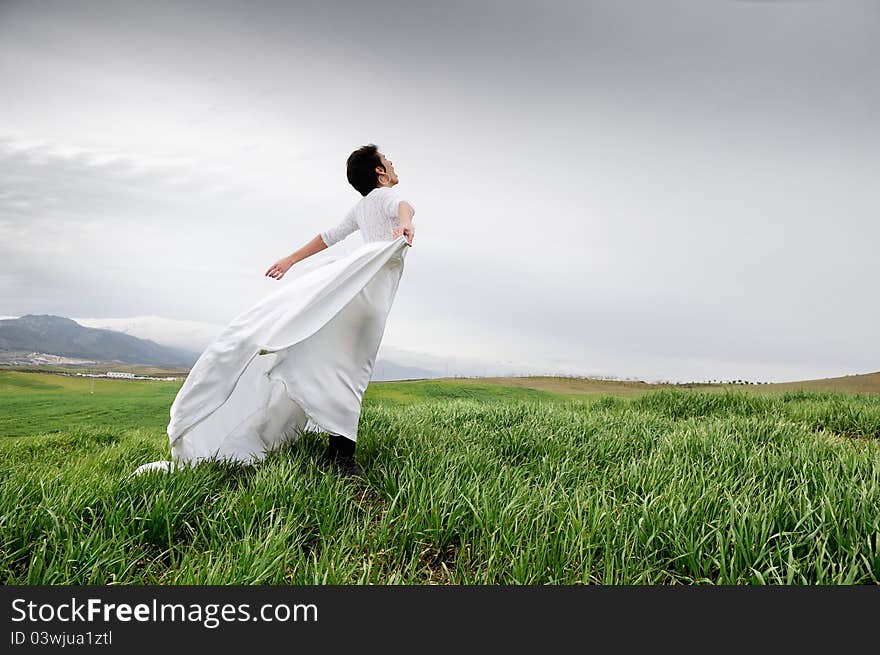 Woman wearing a wedding dress screaming in the fie