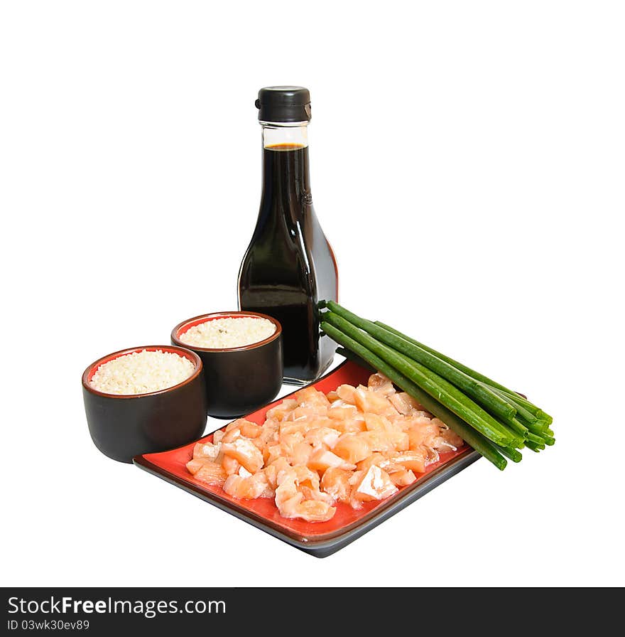 Appetizing sliced salmon in rectangulat dish, bottle of soya sauce, boiled rice in drinking bowl and green leek isolated on white background. Appetizing sliced salmon in rectangulat dish, bottle of soya sauce, boiled rice in drinking bowl and green leek isolated on white background