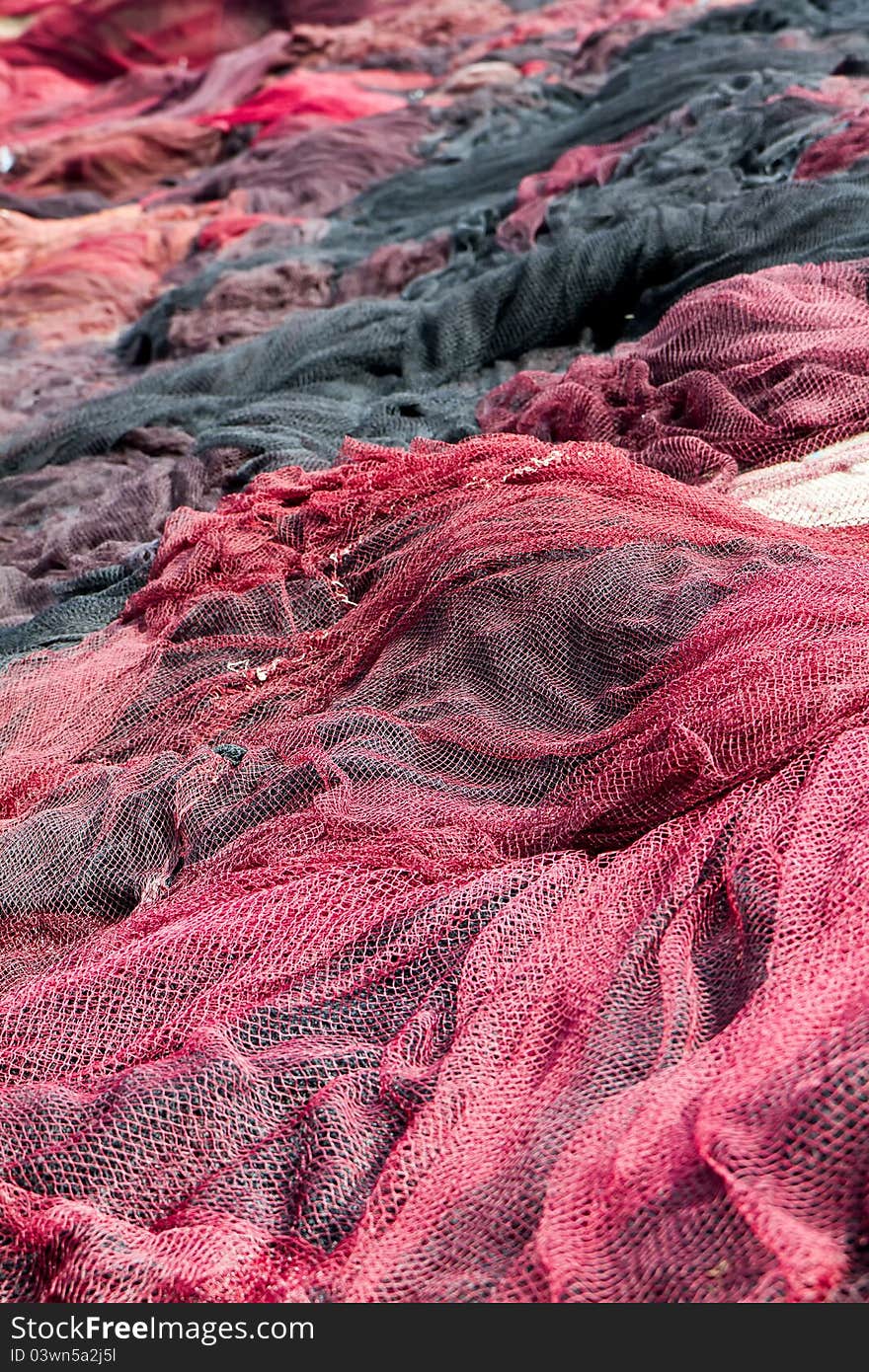 Red fishing nets drying on the port