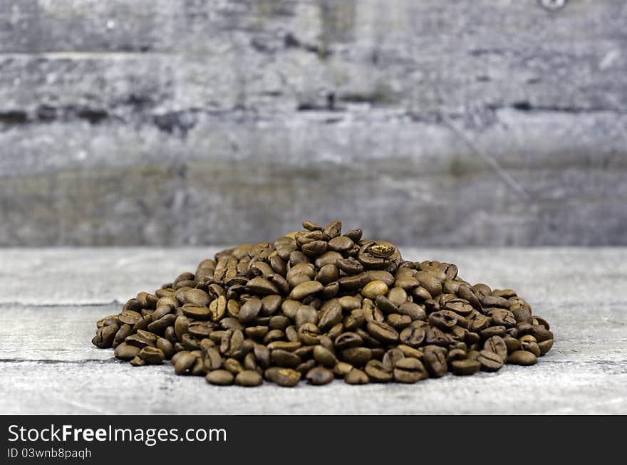 Coffee beans in bulk on wood background