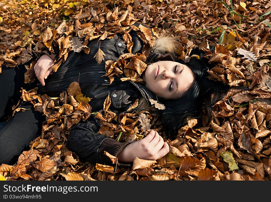 Woman lying in fallen leaves