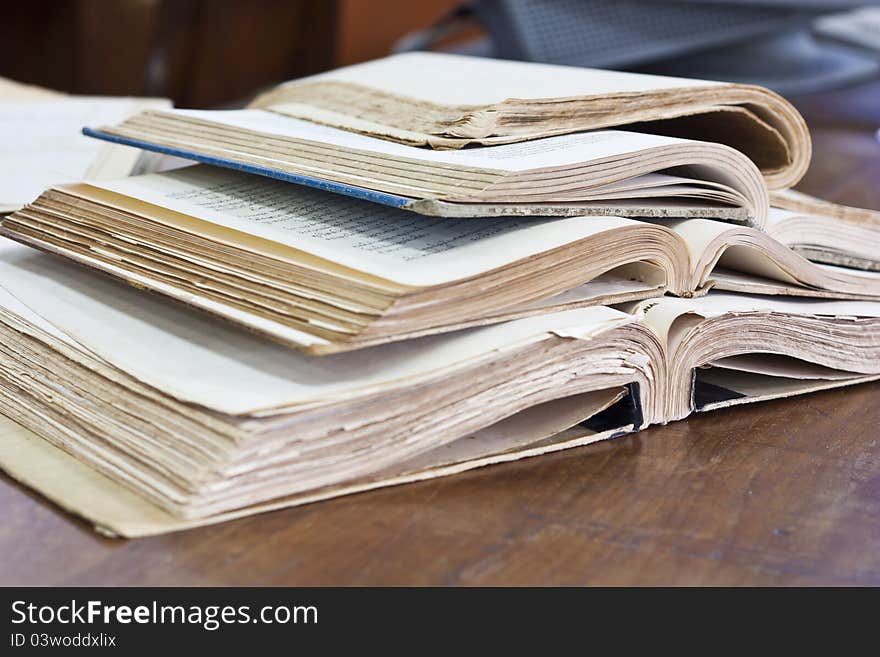 Stack of old books on wooden table