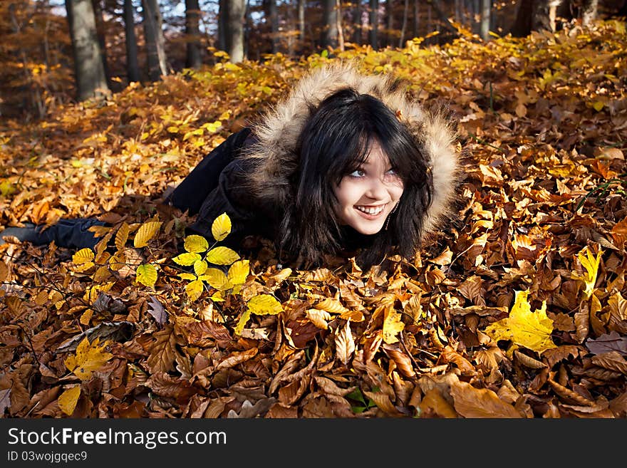 Woman lying in fallen leaves