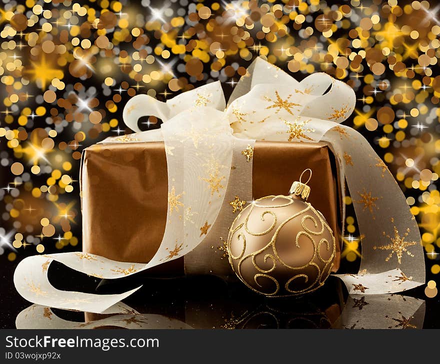 Christmas gift in gold box with bow and candle