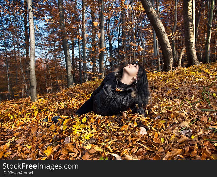 Young woman lying in fallen autumn leaves. Young woman lying in fallen autumn leaves