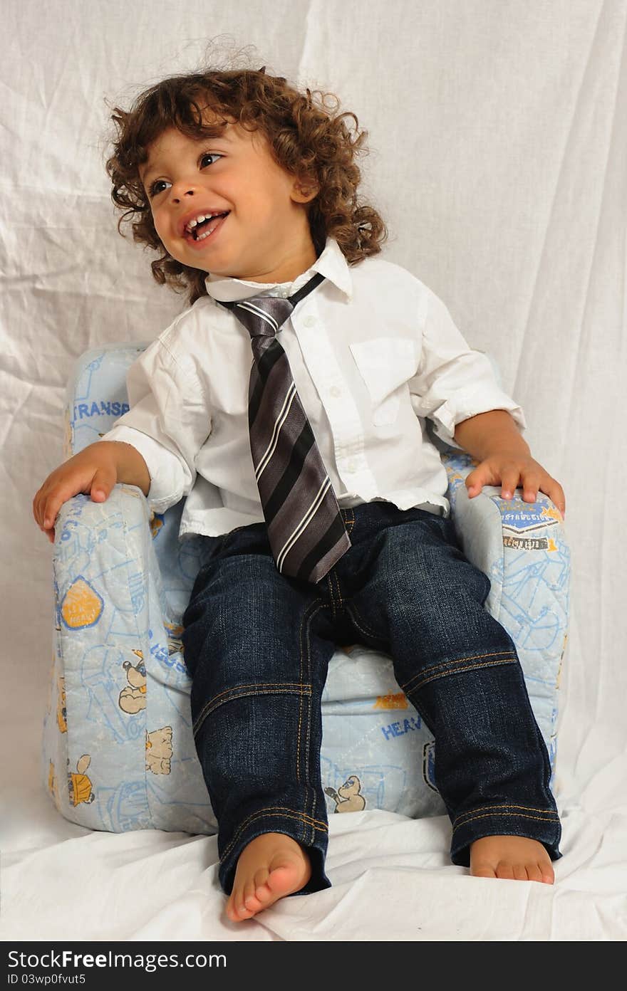 Baby sitting on a chair with necktie. Baby sitting on a chair with necktie