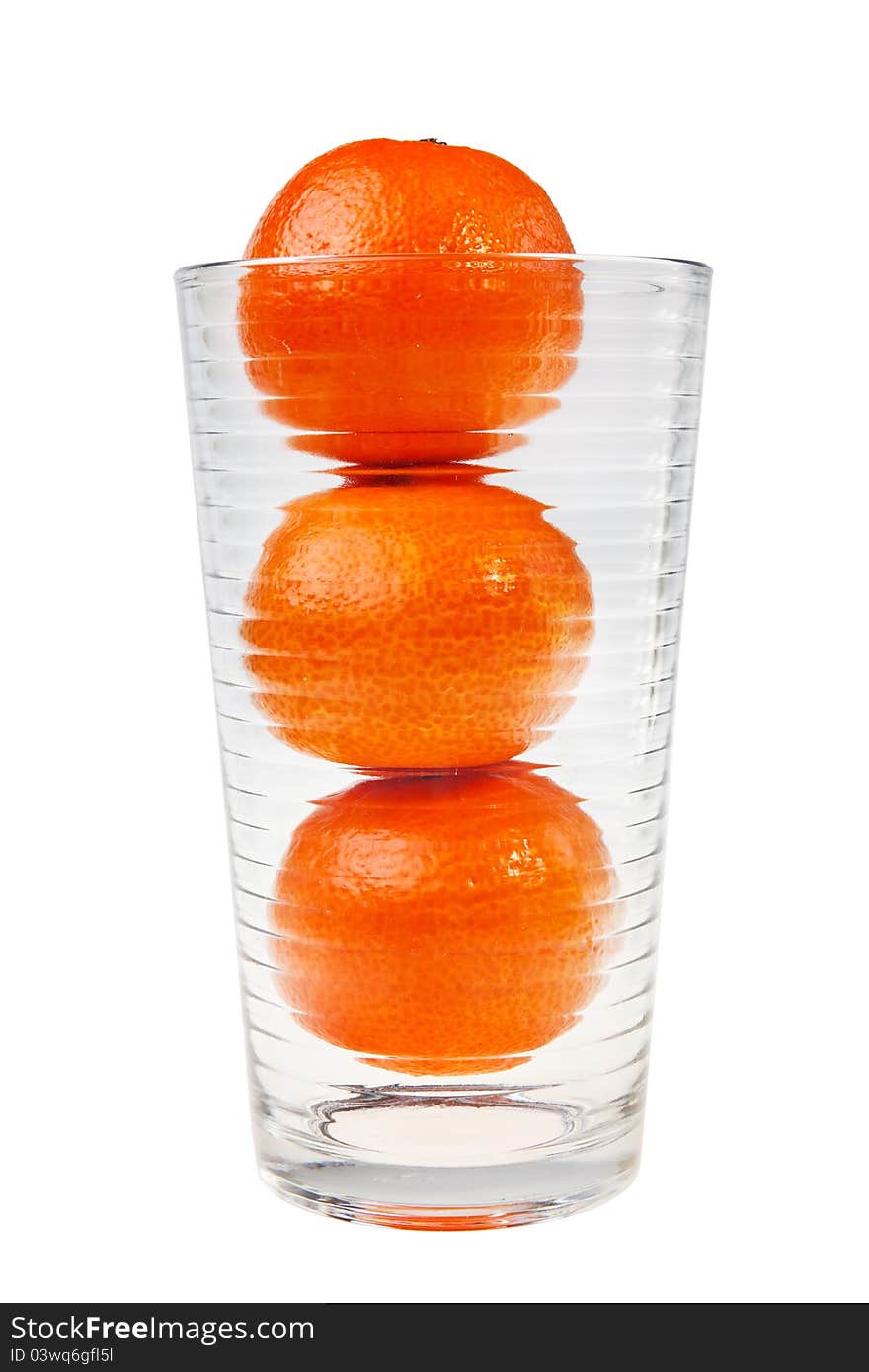 Three mandarin fruits stacked in glass.