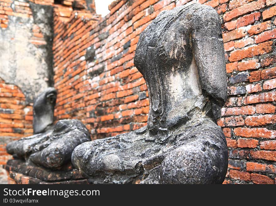 Headless and armless Buddha images sitting inside a ruined temple in Ayutthaya, Thailand