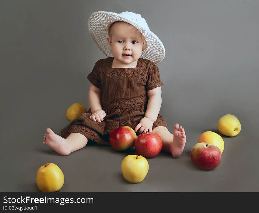 Portrait of the child on a gray background with apples. Portrait of the child on a gray background with apples