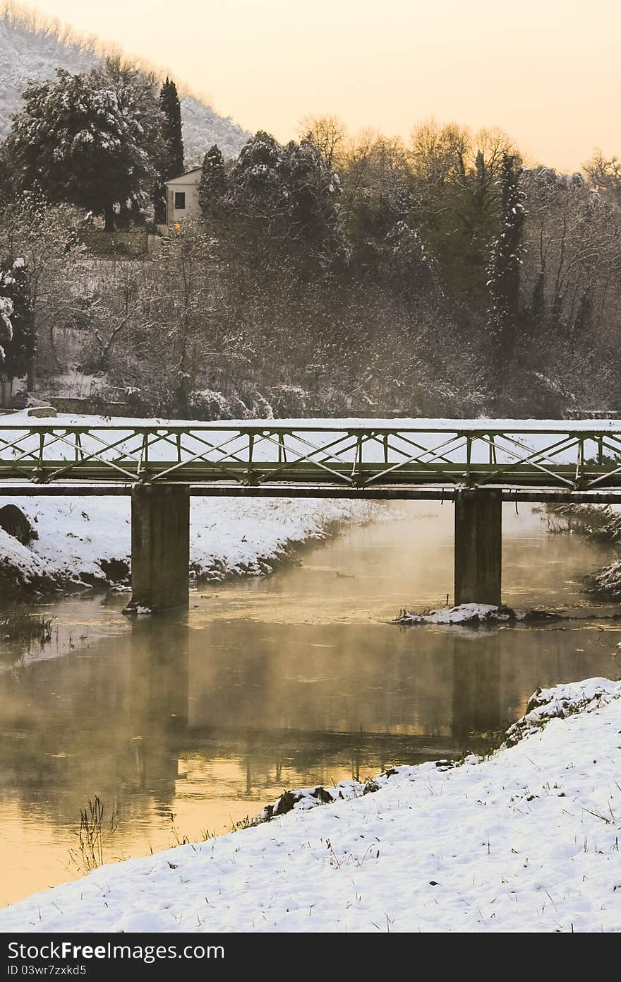 Picture of a winter landscape. A hidden house, a bridge and silence... peaceful atmosphere.