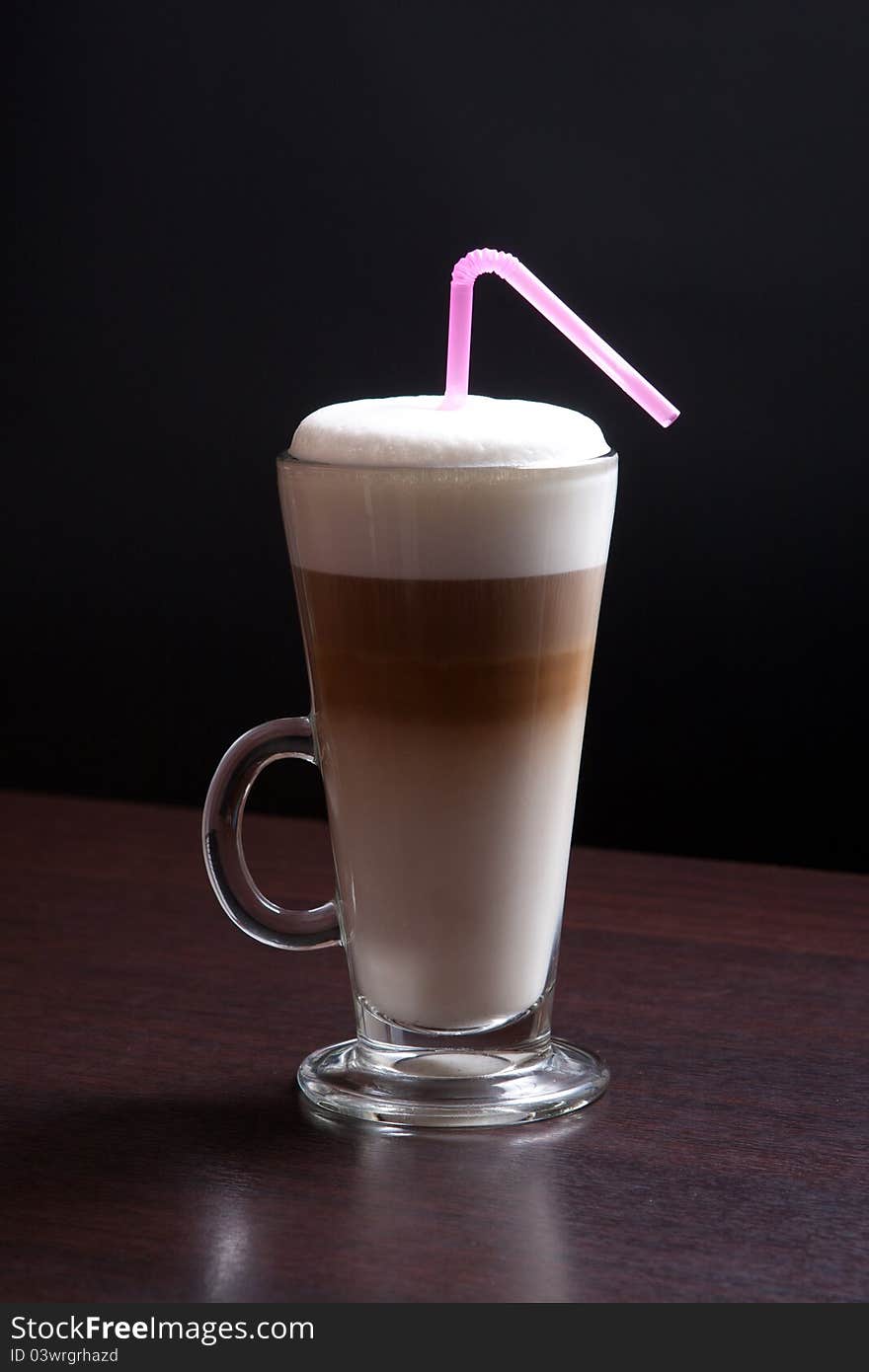 Latte glass with foam and straw