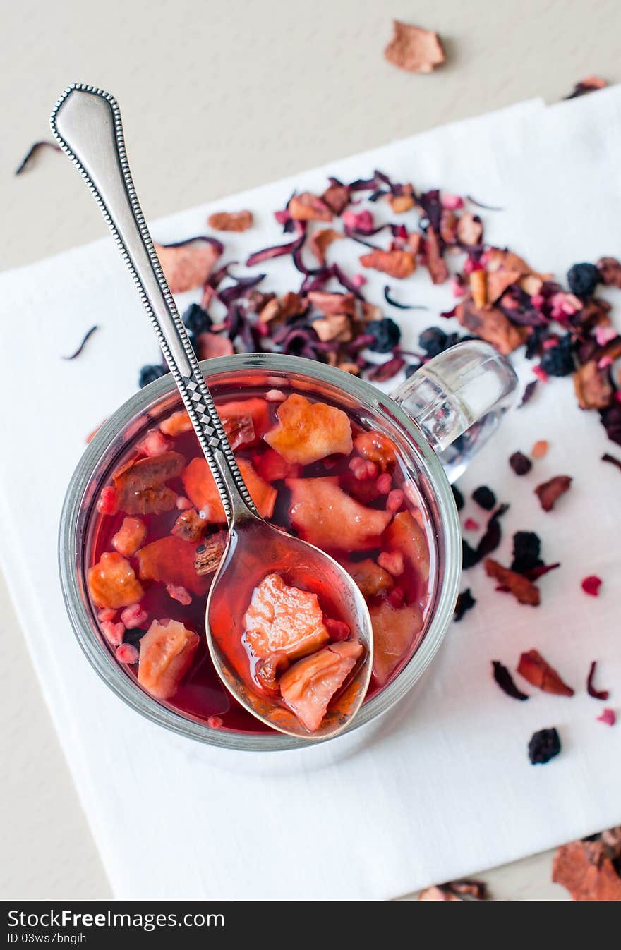 Hot vitamin drink from dried fruits and berries in a transparent cup.