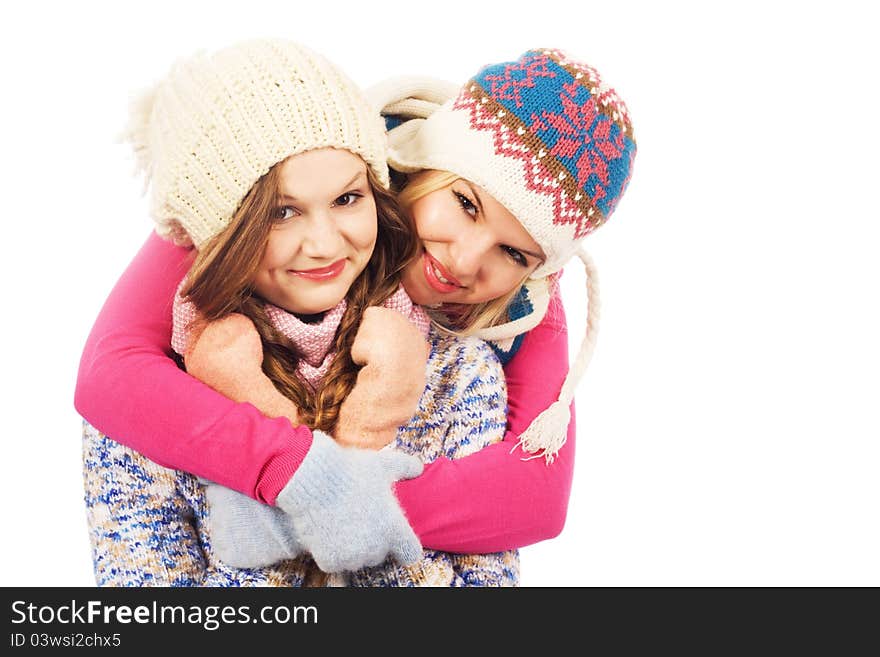 Two lovely girlfriends in winter clothing against white background