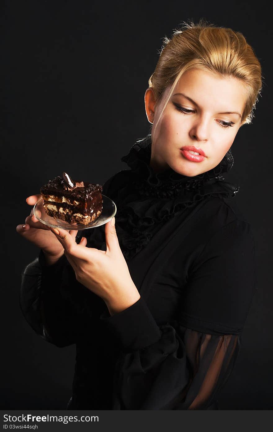 Gorgeous woman with chocolate cake against black