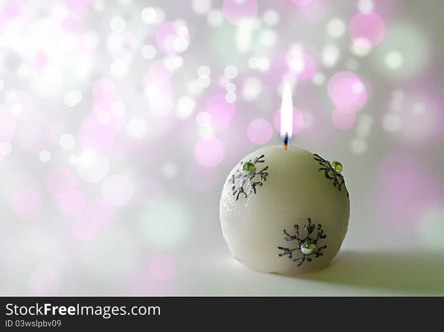 Lit christmas candle on an elegant bokeh background. Lit christmas candle on an elegant bokeh background