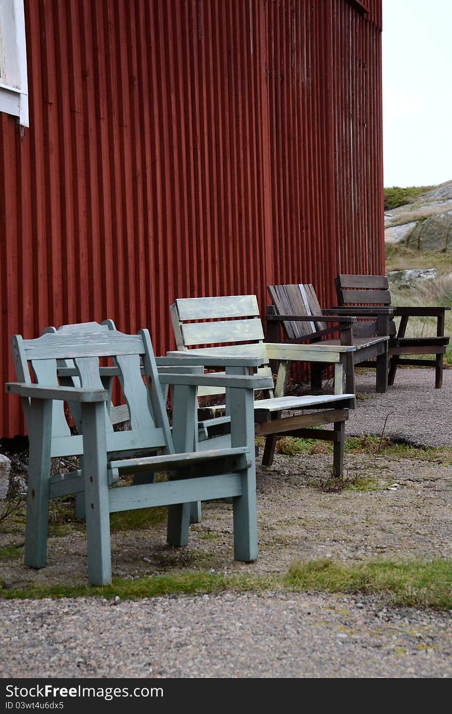 four pair of chairs outside a red old house