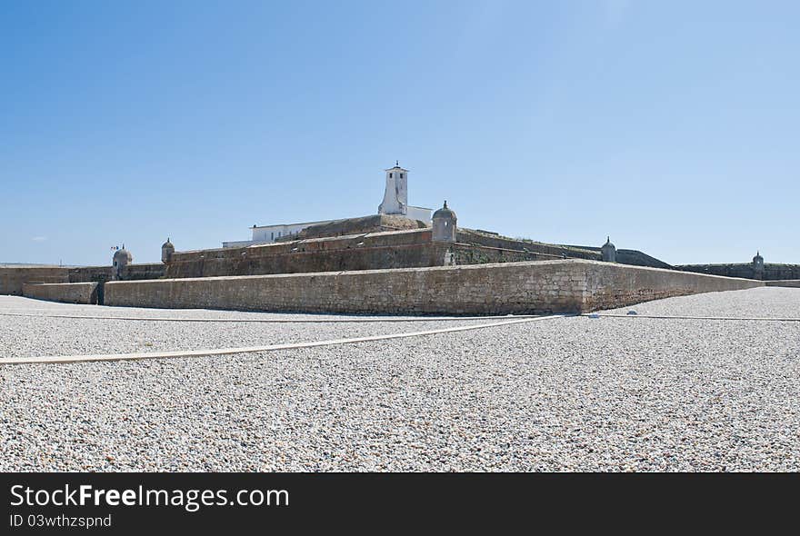 This is a fortress of Peniche, decorated with a garden of small white stones around it.