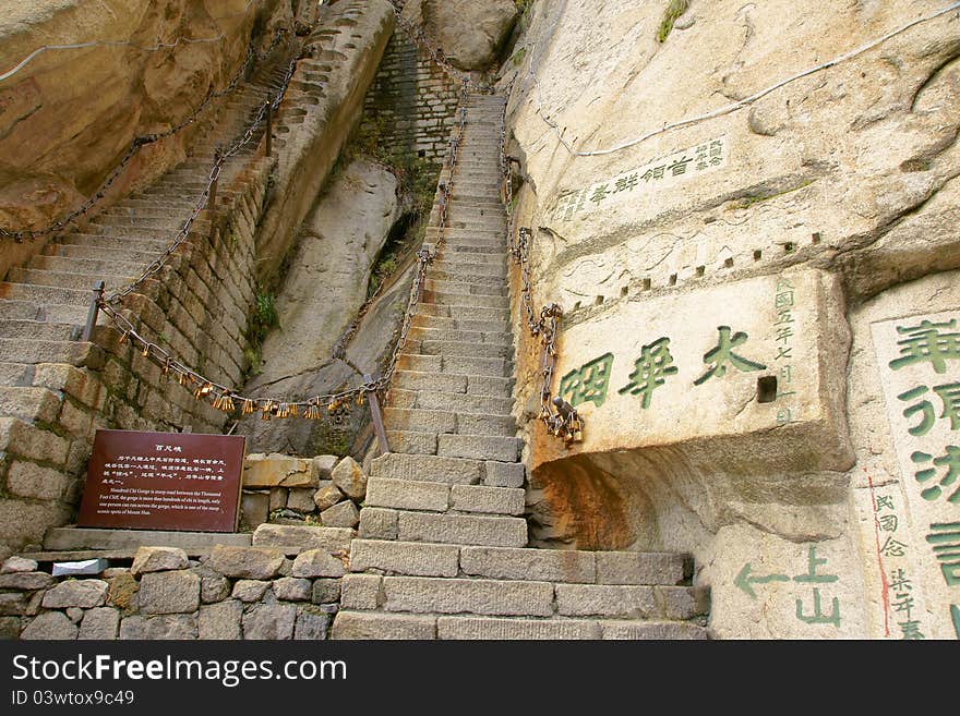 Mountain climbing dangerous road in Mount Hua(Huashan). The words on rock are carved by ancient people. Huashan is one of the most perilous tourist attractions in china. Huashan is located in Huayin, Shaanxi, China. Mountain climbing dangerous road in Mount Hua(Huashan). The words on rock are carved by ancient people. Huashan is one of the most perilous tourist attractions in china. Huashan is located in Huayin, Shaanxi, China.