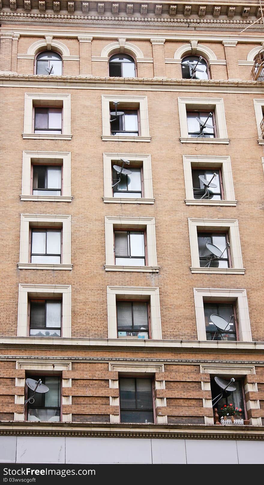 Residential house wall with multiple satellite dishes placed in windows. Residential house wall with multiple satellite dishes placed in windows