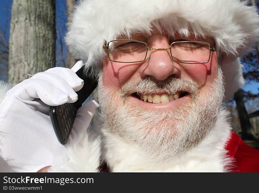 Santa making a last minute call on his cell phone. Santa making a last minute call on his cell phone.