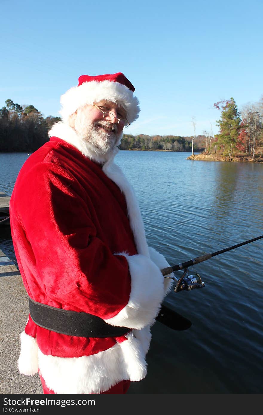 Santa fishing in a beautiful lake setting in Autumn. Santa fishing in a beautiful lake setting in Autumn