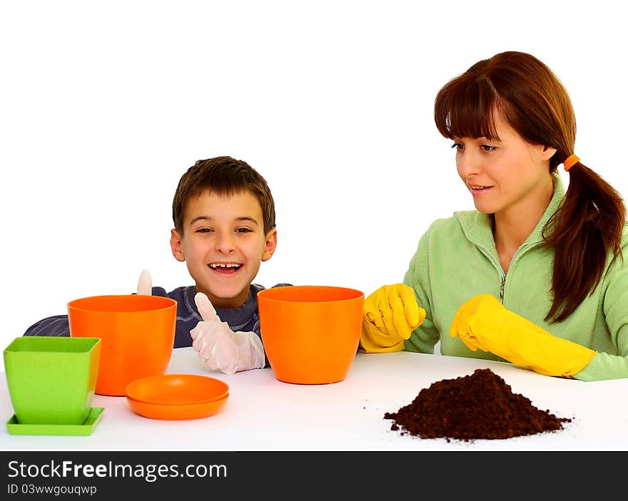 Mother and her son (boy, kid) ready to plant flowers isolated on a white background with different color flowerpots. Mother and her son (boy, kid) ready to plant flowers isolated on a white background with different color flowerpots