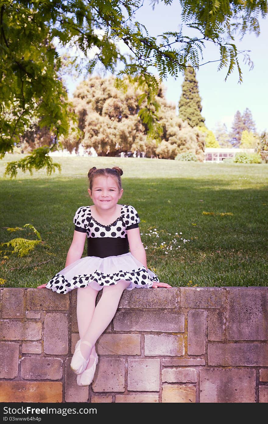 Vintage style portrait of a little girl sitting on a brick wall. Vintage style portrait of a little girl sitting on a brick wall.