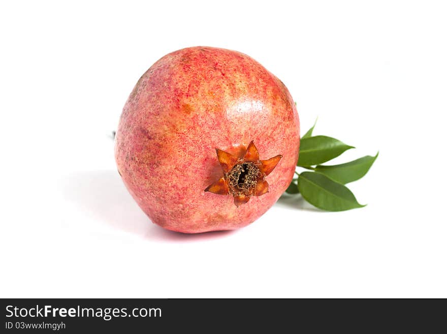 Juicy pomegranate with leaves on white