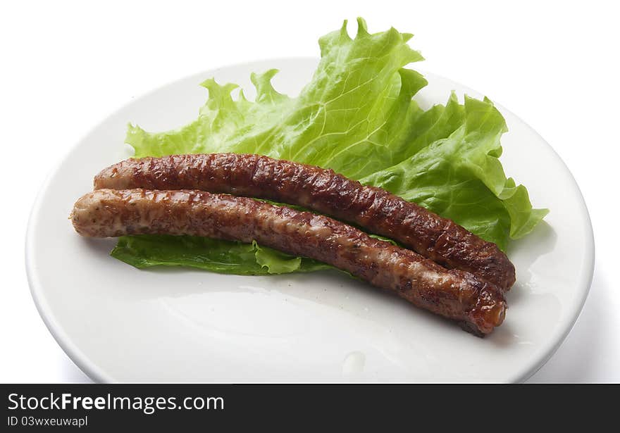 Home-made sausages with fresh lettuce on the plate