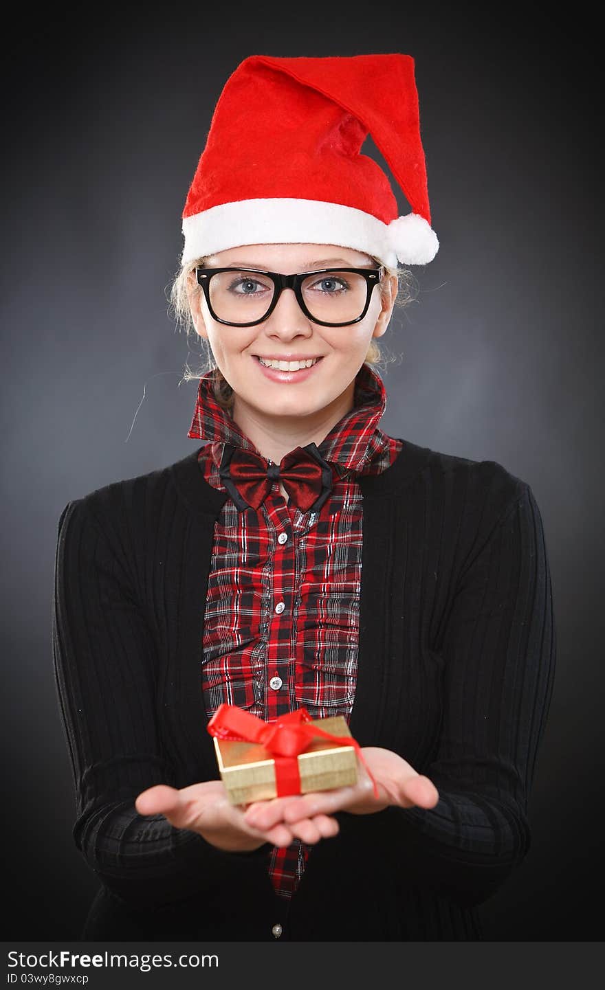 Blonde young intelligent woman gives gift on Christmas Eve. Blonde young intelligent woman gives gift on Christmas Eve