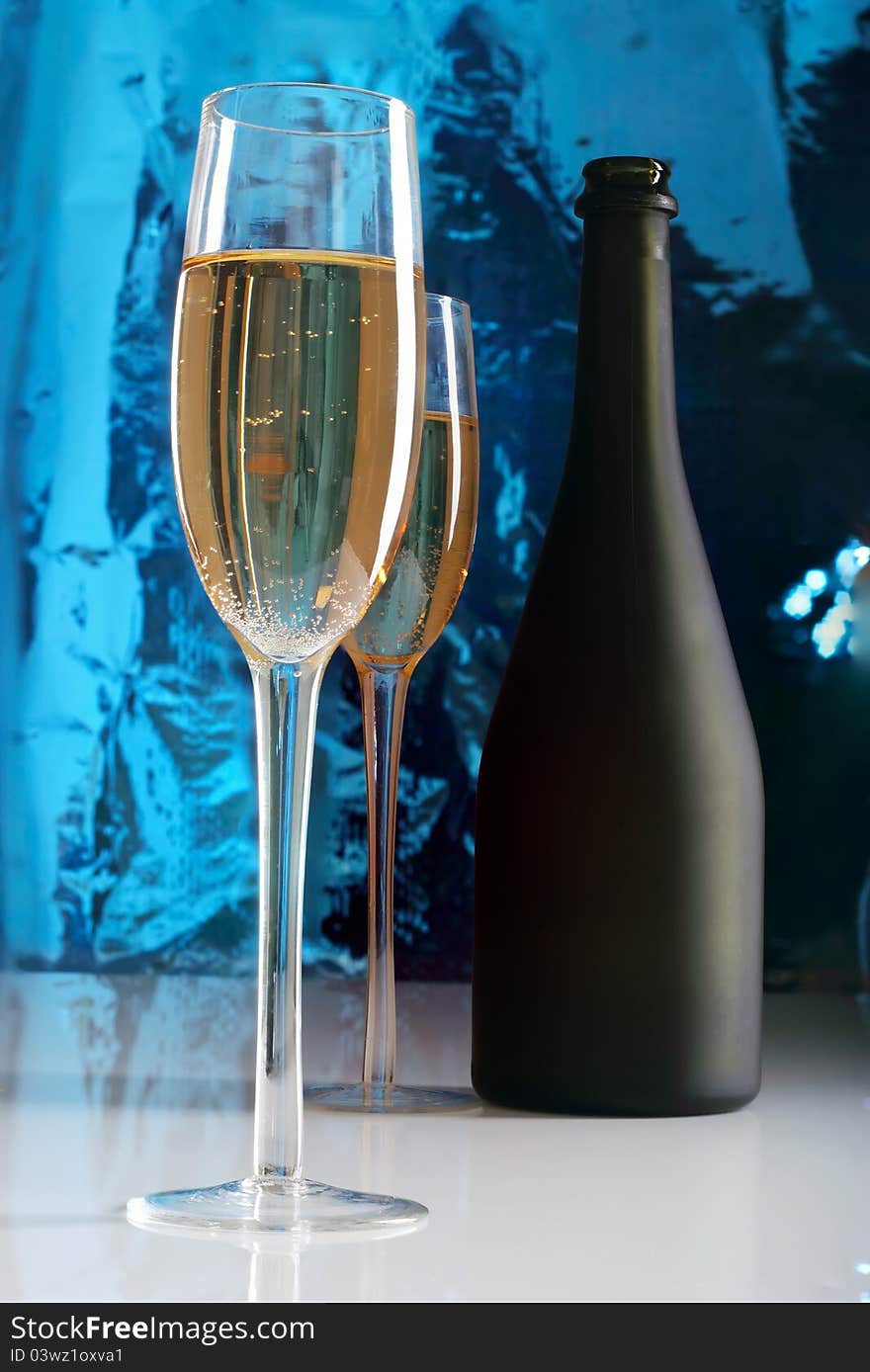 Glass of champagne and bottle.Blue background