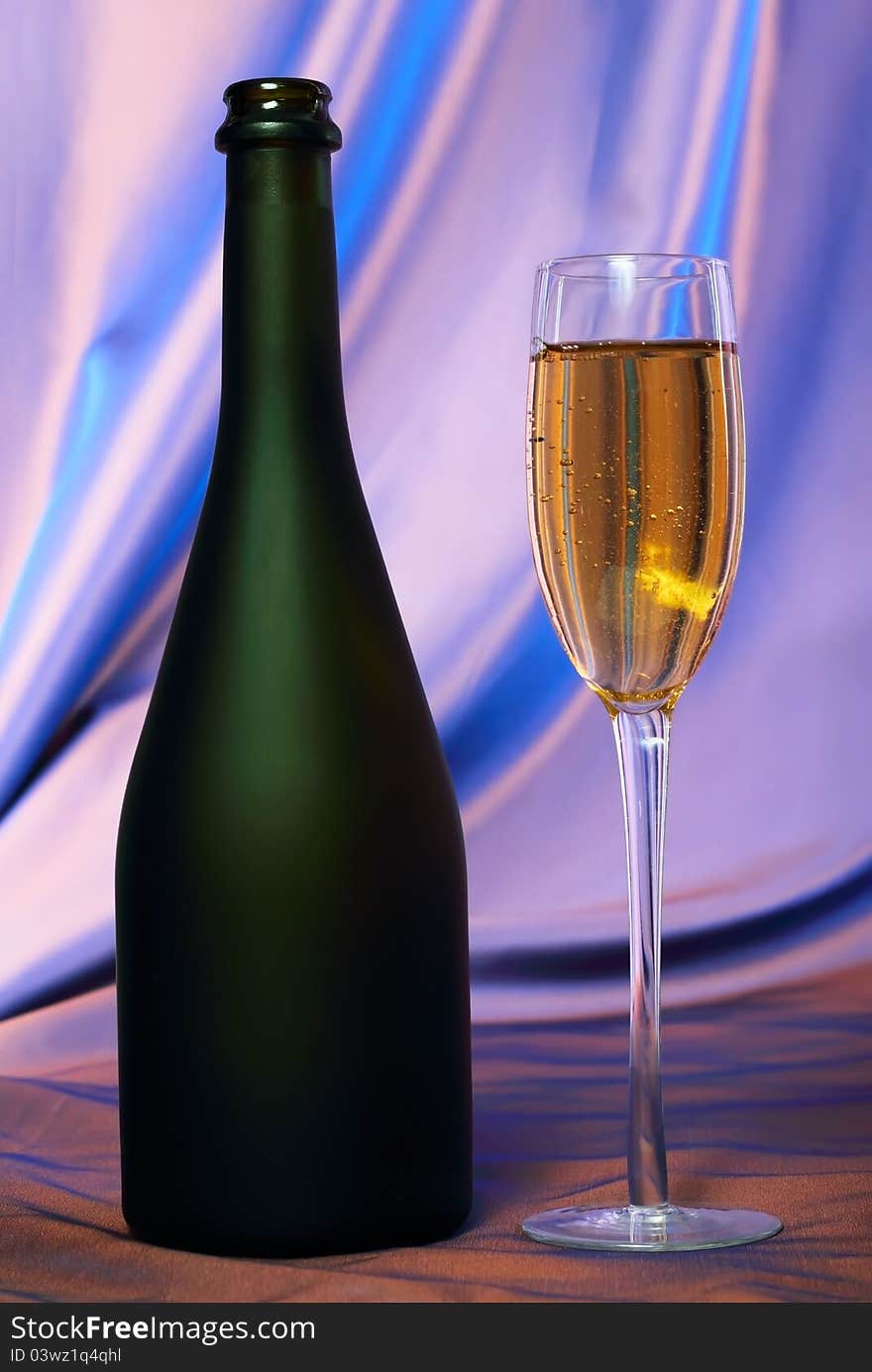 Glass of champagne and bottle.Blue background