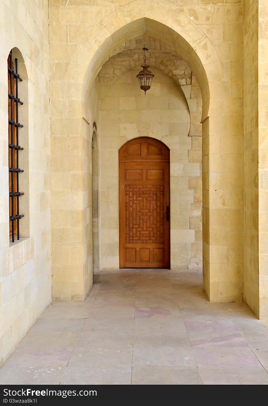 An arched entrance in a Lebanese palace with a carved wooden door. An arched entrance in a Lebanese palace with a carved wooden door