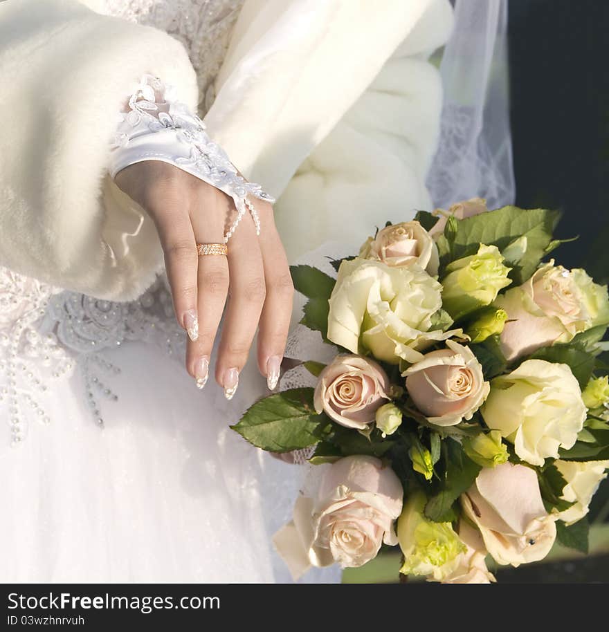 Hand of fiancee with a wedding ring a bouquet from roses. Hand of fiancee with a wedding ring a bouquet from roses