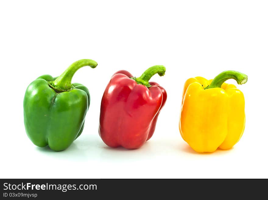 Red, yellow and green bell peppers on the white backgro