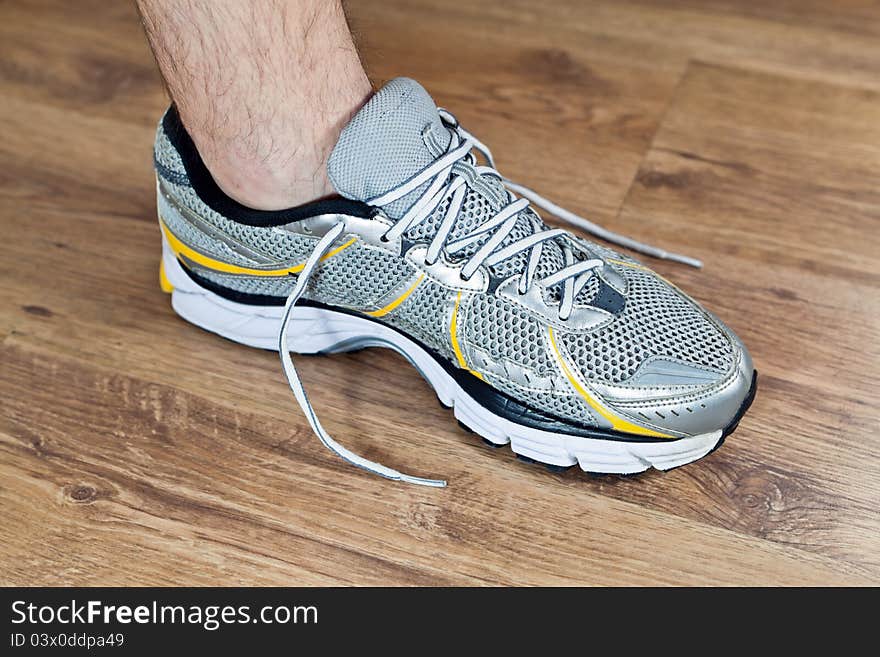 Man tying sports shoe at gym before workout, exercising indoors. Man tying sports shoe at gym before workout, exercising indoors