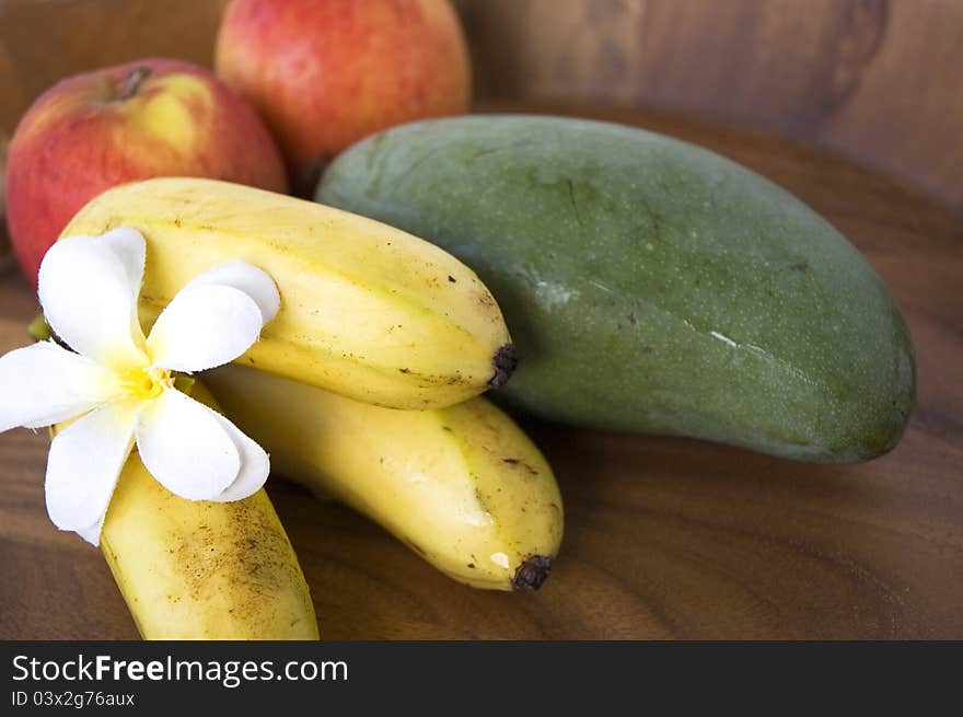 Tropical fruits banana,mango and apples on wooden tray. Tropical fruits banana,mango and apples on wooden tray