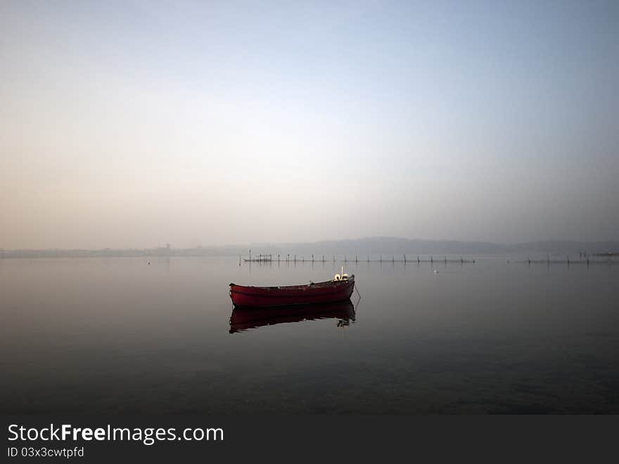 Red fishing boat and fish trap in Littel Belt a foggy sunny morning. Red fishing boat and fish trap in Littel Belt a foggy sunny morning.