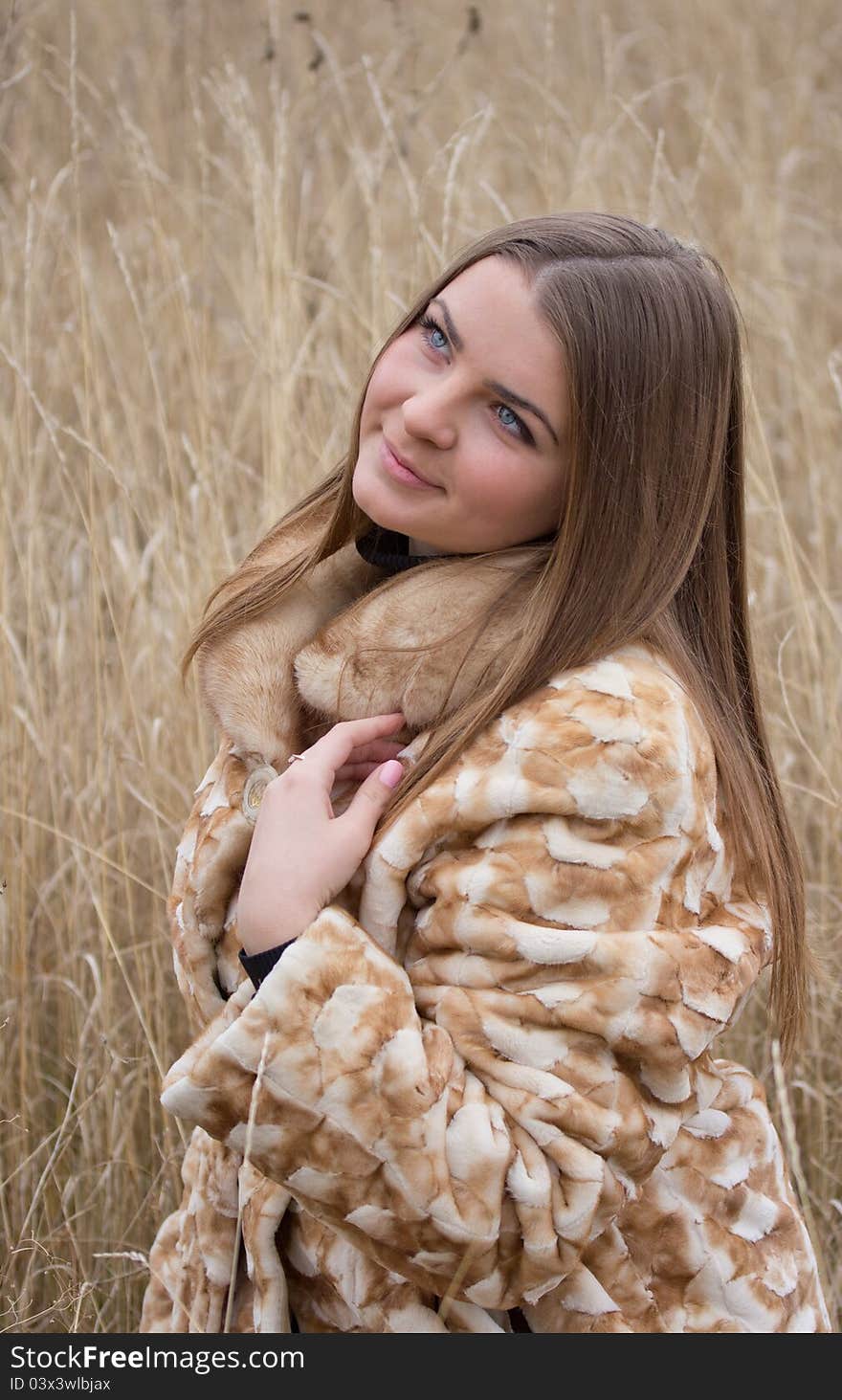 Young beautiful girl in a wheat field. She looks up and smiles. Young beautiful girl in a wheat field. She looks up and smiles